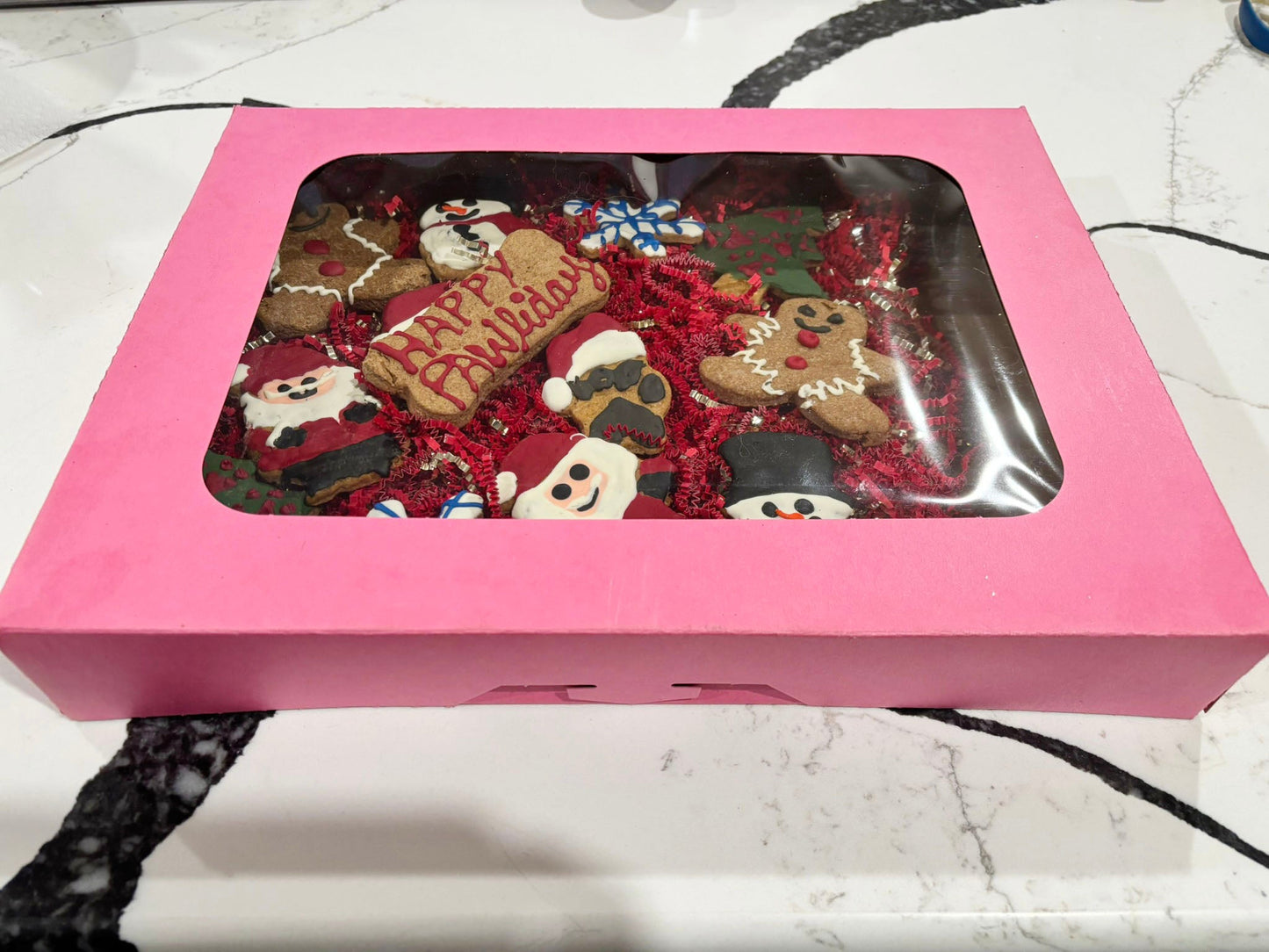 Pink gift box with Christmas-themed cookies inside on a marble surface