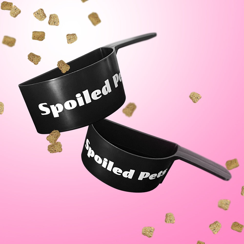 Two black pet bowls with 'Spoiled Pet' text on a pink background with gold dog treats.