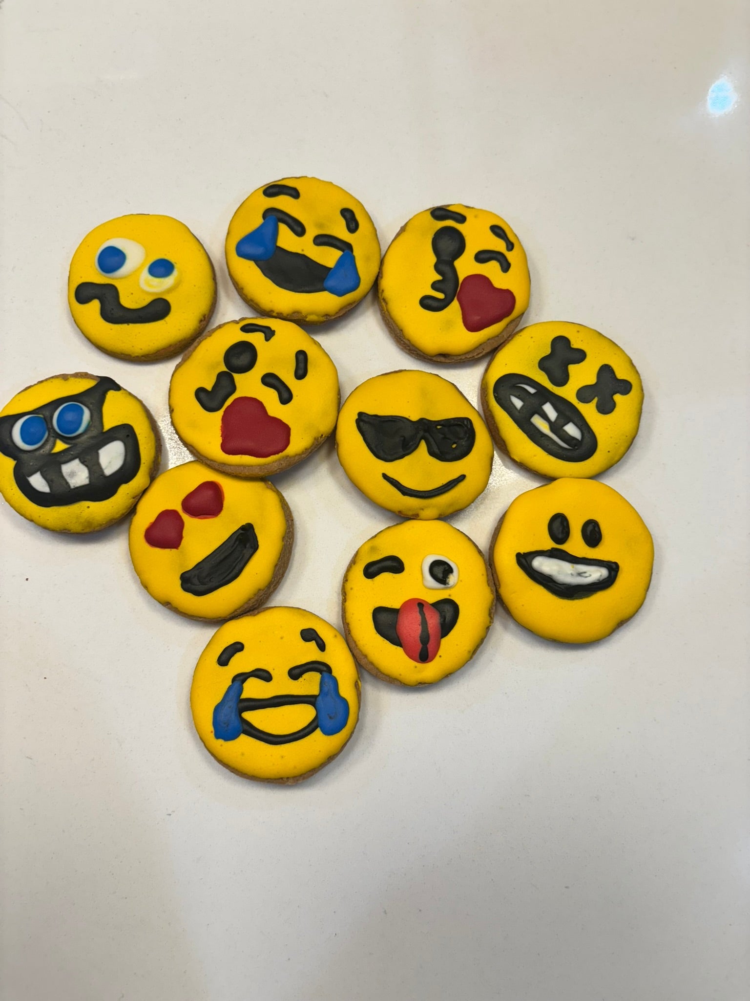Set of emoji-themed cookies on a white surface