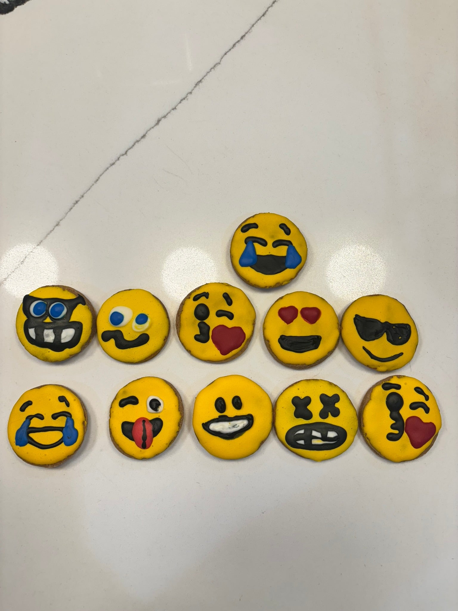 Set of emoji-themed cookies on a white surface
