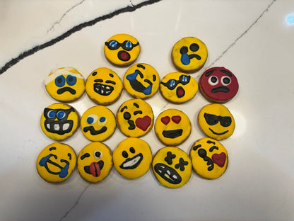Collection of emoji-themed cookies on a white surface