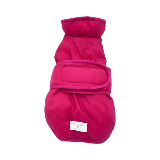 Pink dog coat with a brand label on a white background