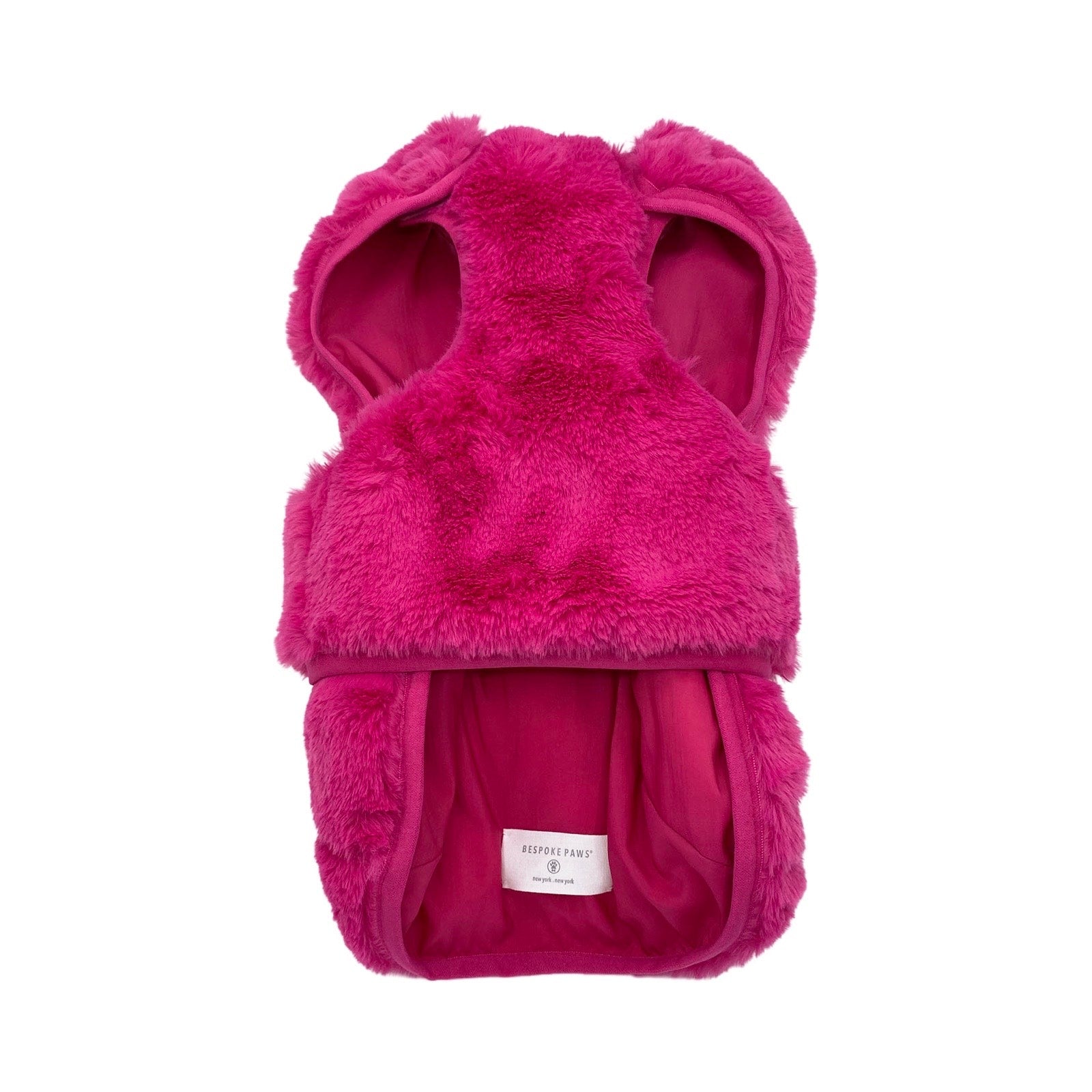 Pink fluffy dog coat with a brand label on a white background