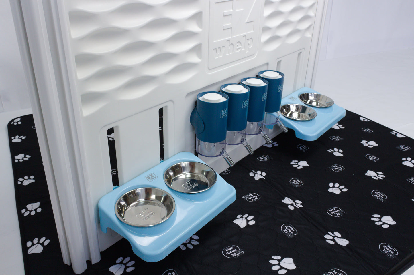 Pet feeding station with blue elevated bowls on a black mat with paw prints.