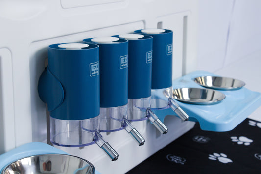 Pet feeding station with blue water dispensers and metal bowls on a white wall.