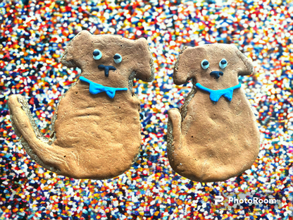 Two clay dog figures with blue collars on a colorful sprinkles background