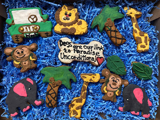 Collection of animal-themed cookies on a blue textured surface with a heart-shaped cookie reading 'Dogs are our link to paradise. Unconditional.