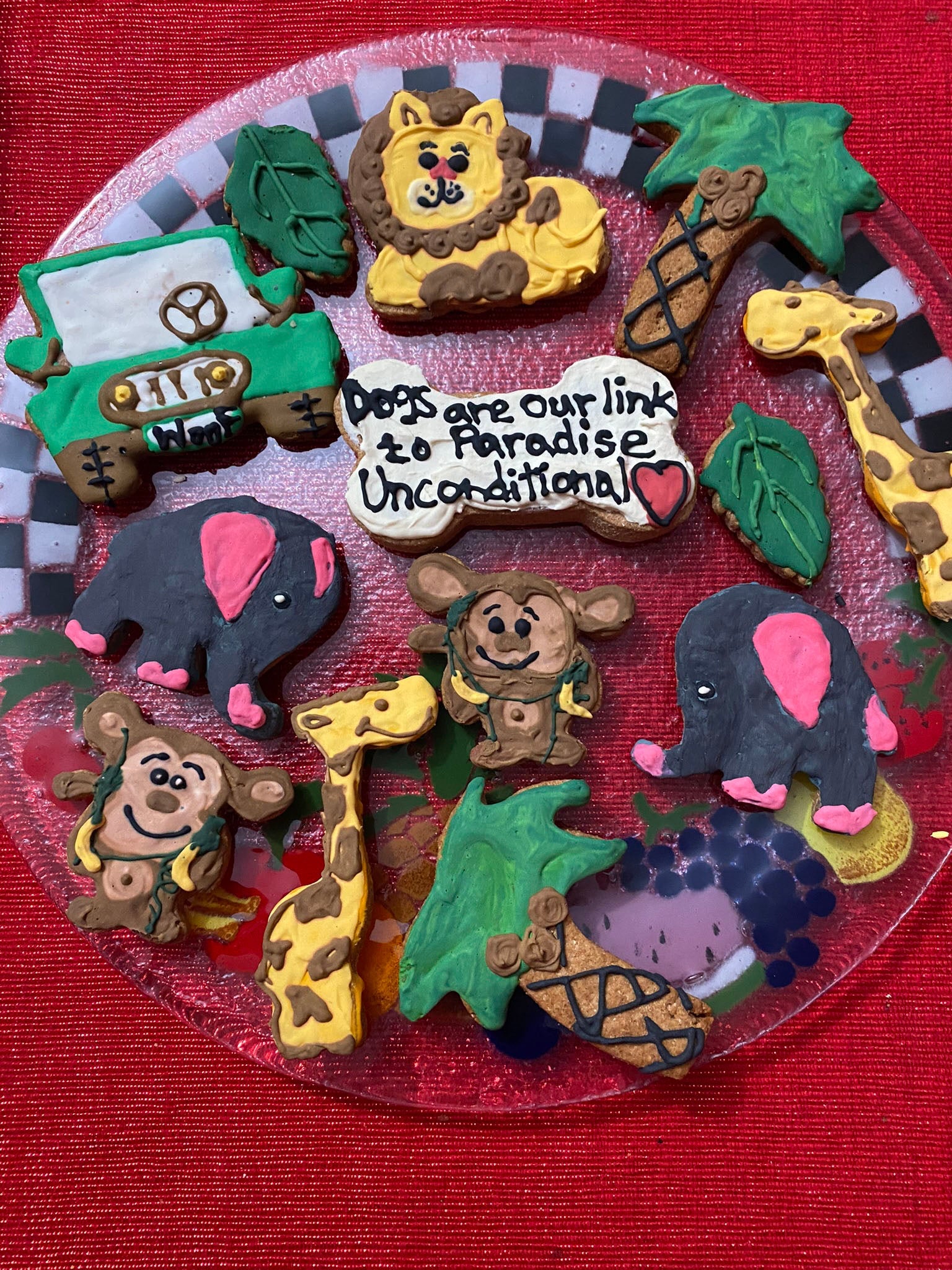 Collection of animal-themed cookies on a red plate with a checkered border