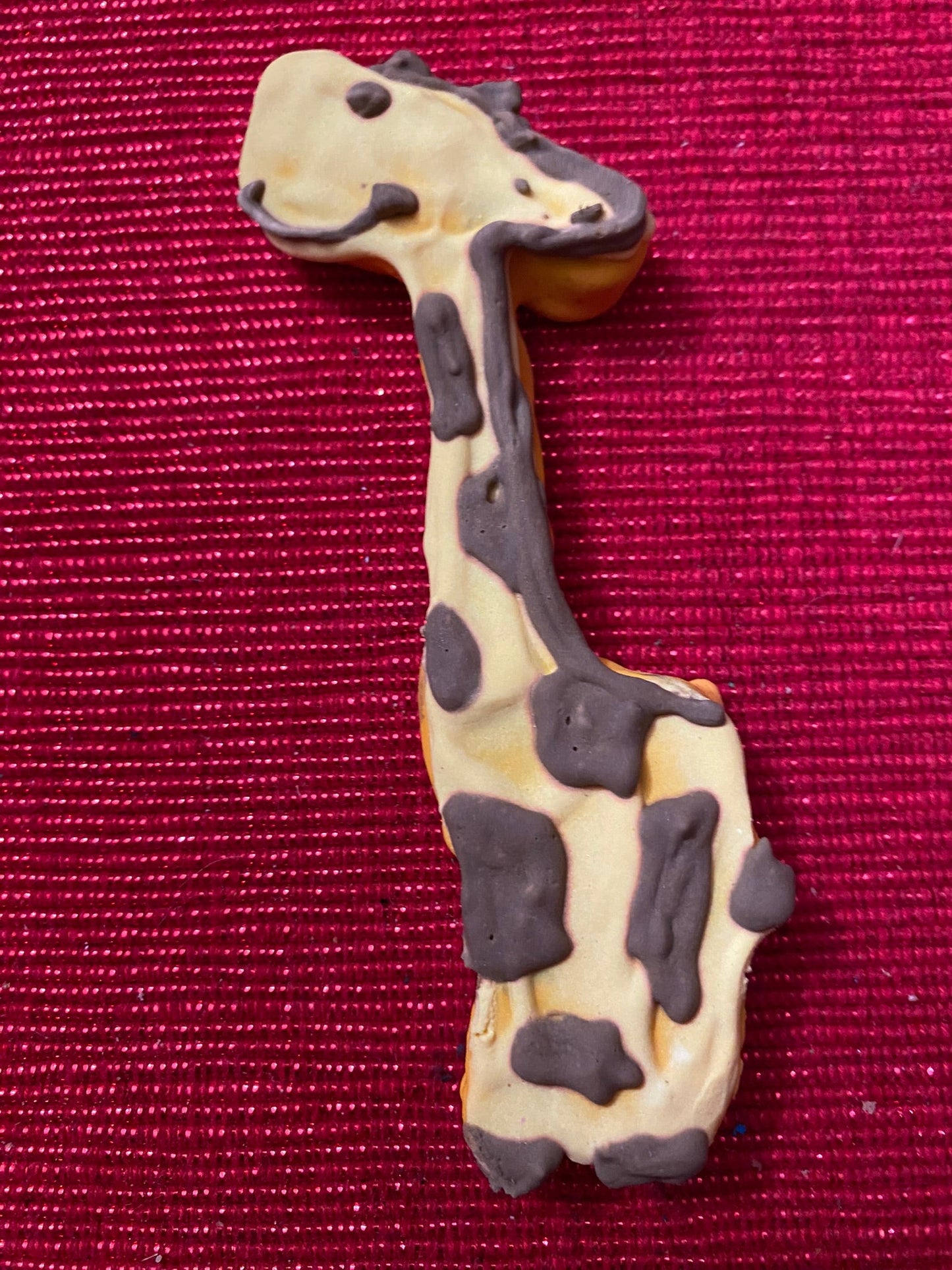 Giraffe-shaped cookie on a red textured background