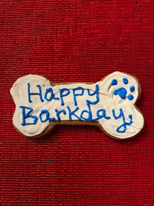 Dog bone-shaped cookie with 'Happy Barkday' text on a red background