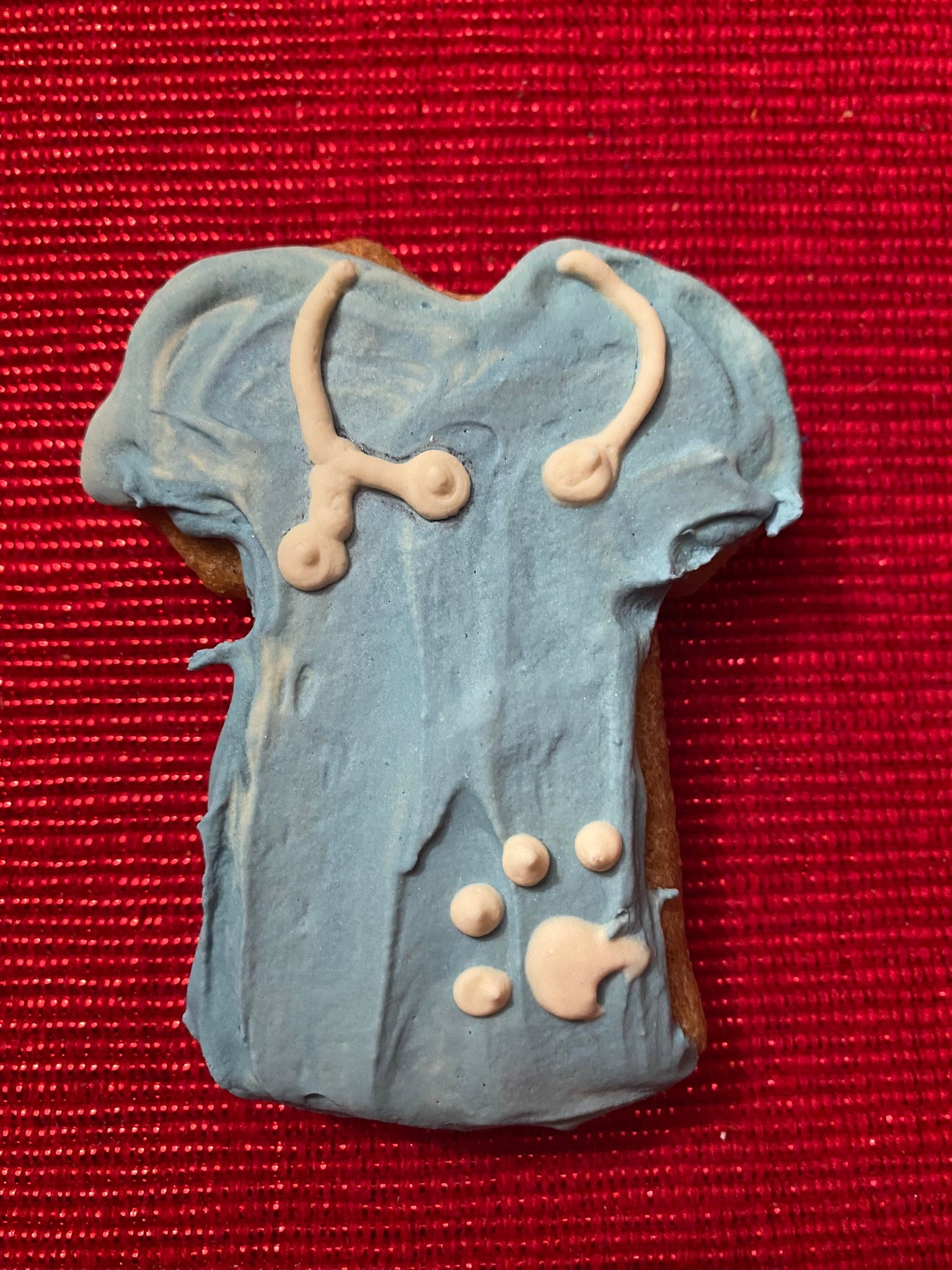 Cookie shaped like a doctor's outfit on a red background