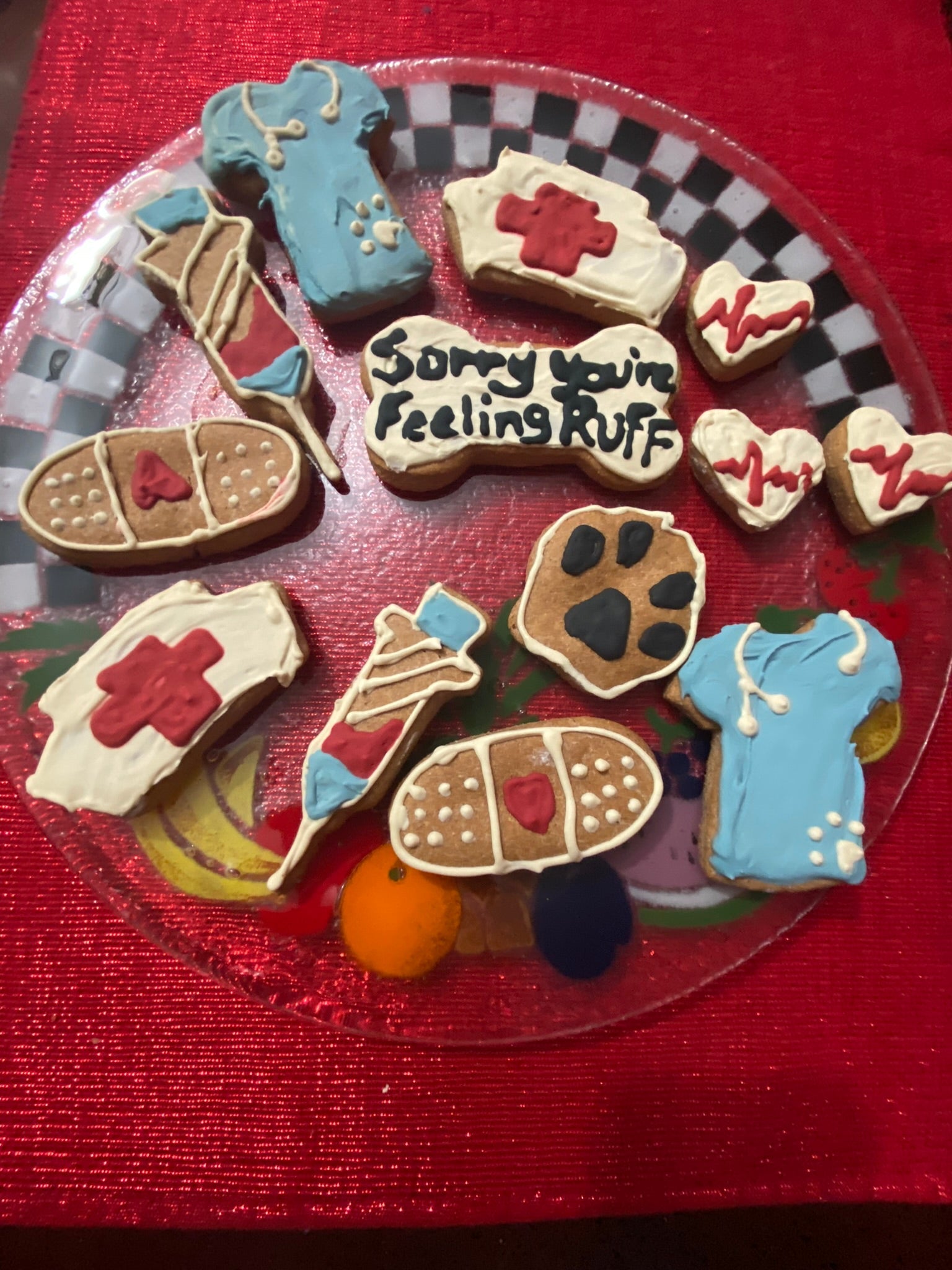 Decorative cookies shaped like medical supplies and a paw print on a red background