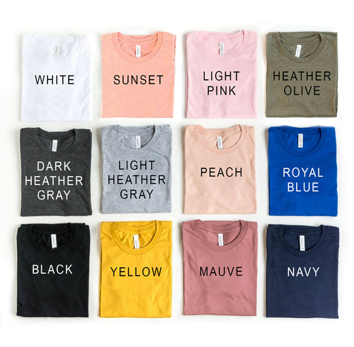 Collection of folded t-shirts in various colors with labels on a white background