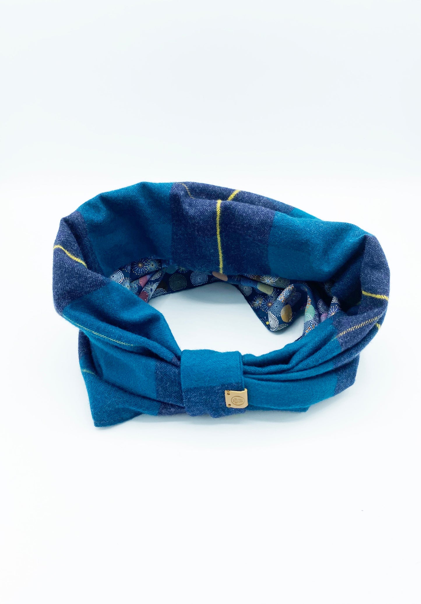 Blue plaid headband with a gold tag on a white background