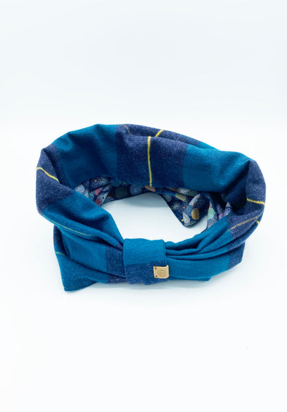 Blue plaid headband with a gold tag on a white background