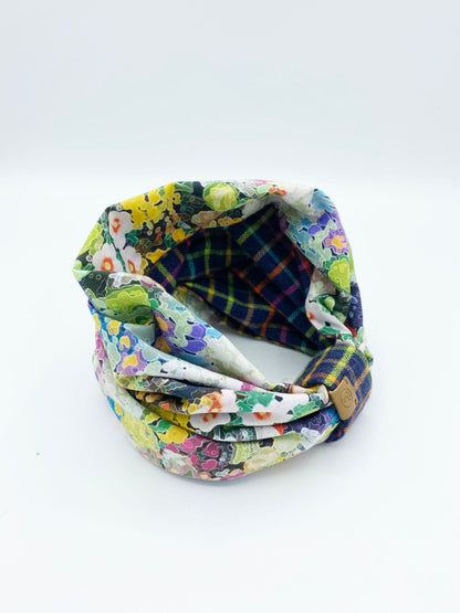 Colorful fabric headband with floral and plaid patterns on a white background