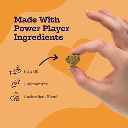 Hand holding a heart-shaped supplement with ingredients listed on an orange background