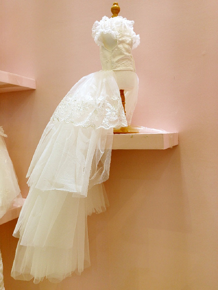 White wedding dress on a mannequin against a pink wall