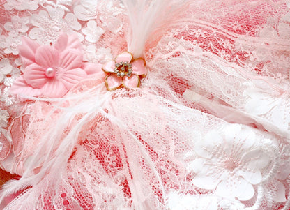 Close-up of pink and white lace fabric with floral embellishments