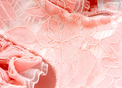 Close-up of pink lace fabric with intricate patterns