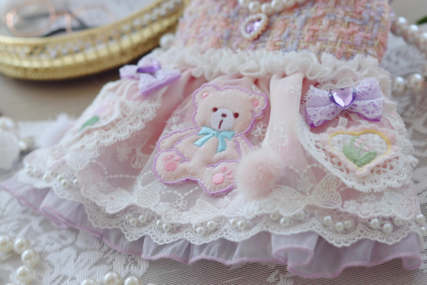 Delicate lace dress with teddy bear design on a textured surface