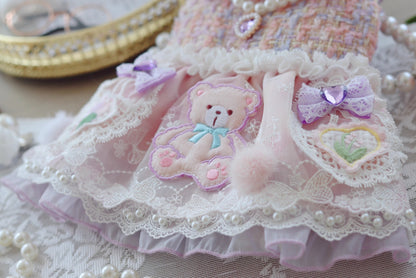 Delicate lace dress with teddy bear design on a textured surface