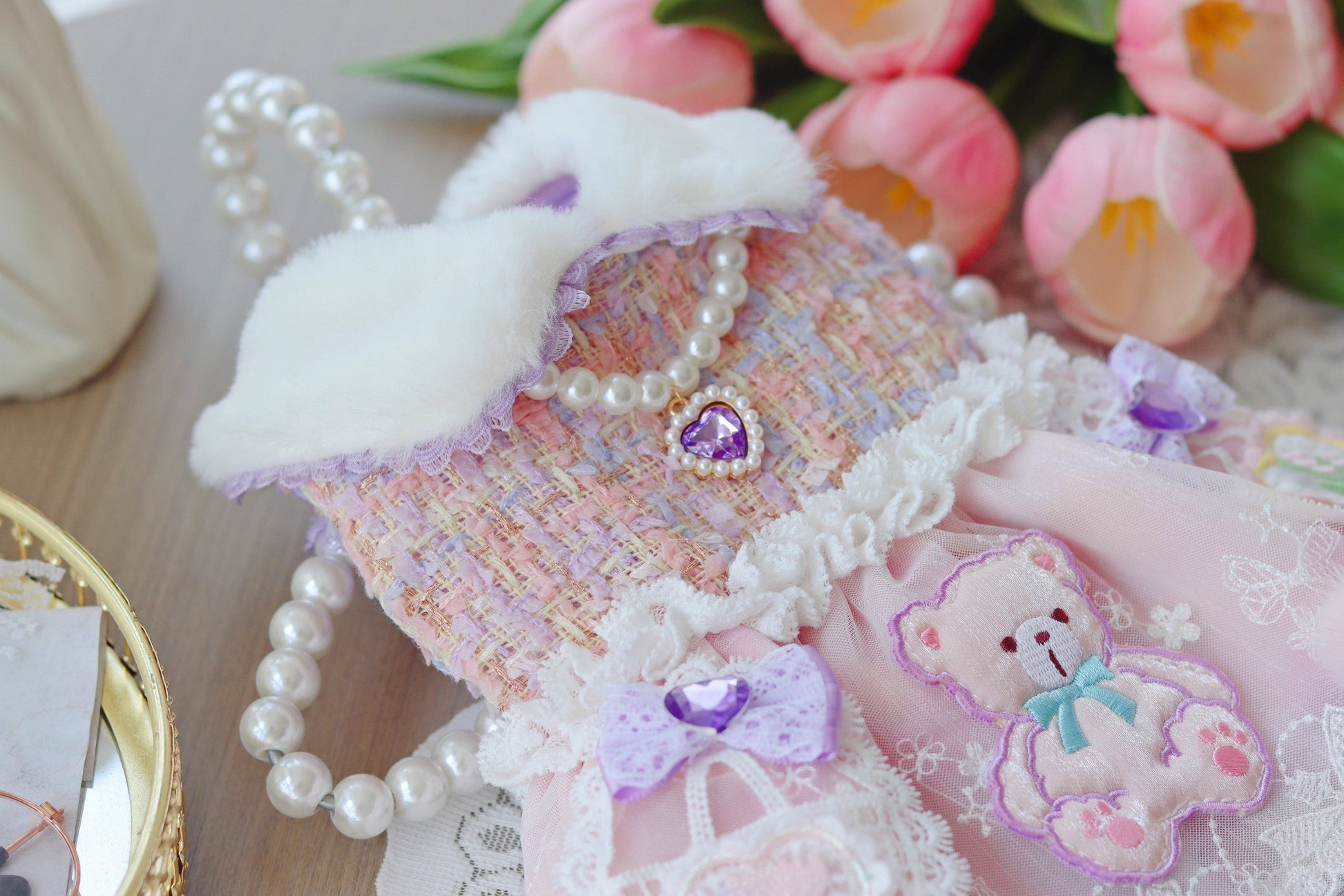 Decorative item with lace, pearls, and a teddy bear design on a floral background