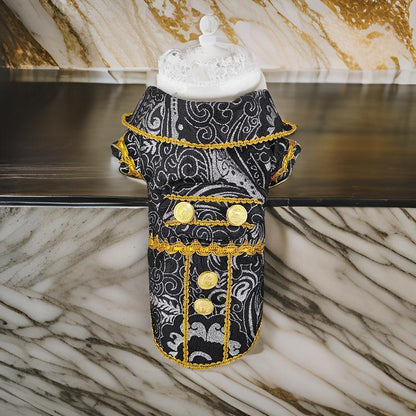 Decorative dog coat with black and gold pattern on a marble surface