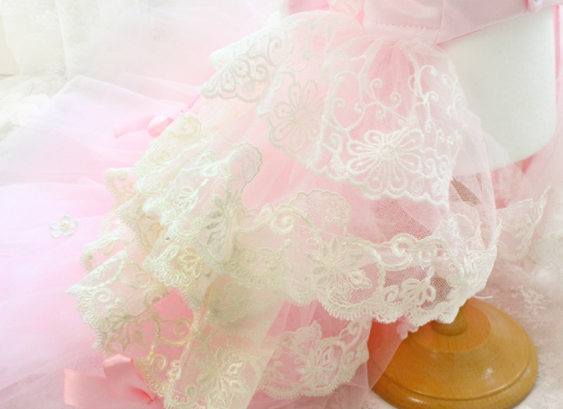 Close-up of lace fabric with a wooden rod on a pink background