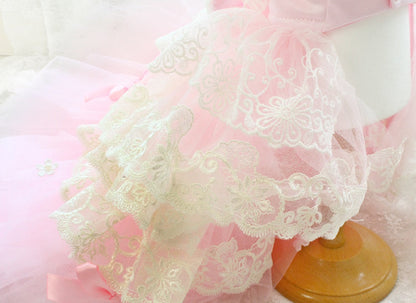 Close-up of lace fabric with a wooden rod on a pink background