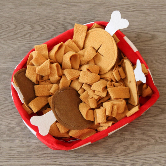 Red container filled with dog chew toys on a wooden surface