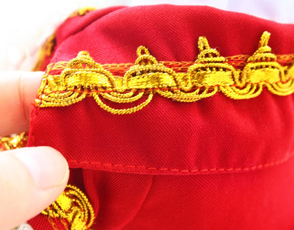 Close-up of a red fabric with gold embroidery, held by a hand.