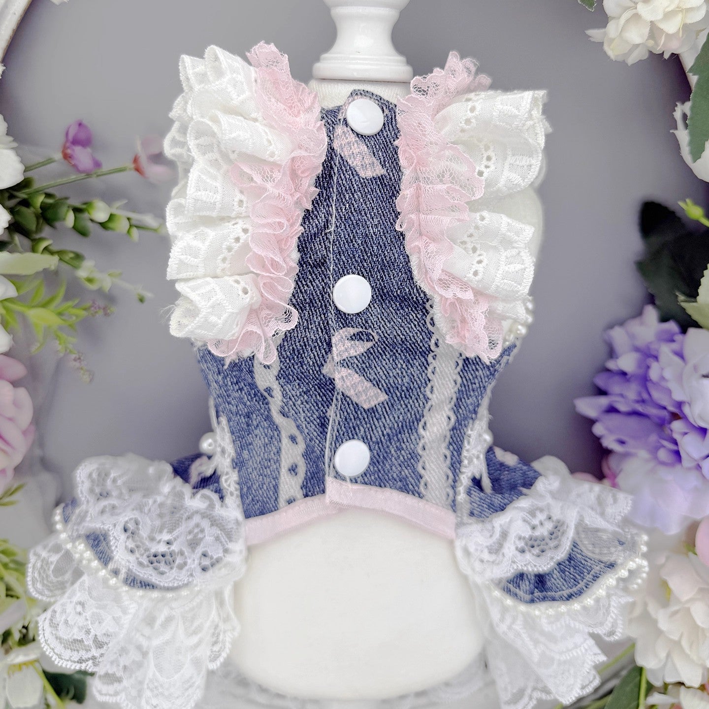 Denim dress with lace and buttons on a floral background