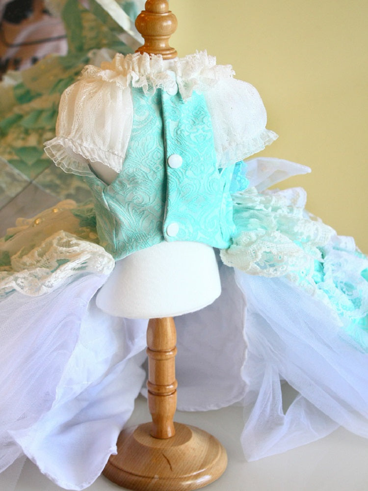Mannequin wearing a turquoise dress with white lace on a wooden stand.
