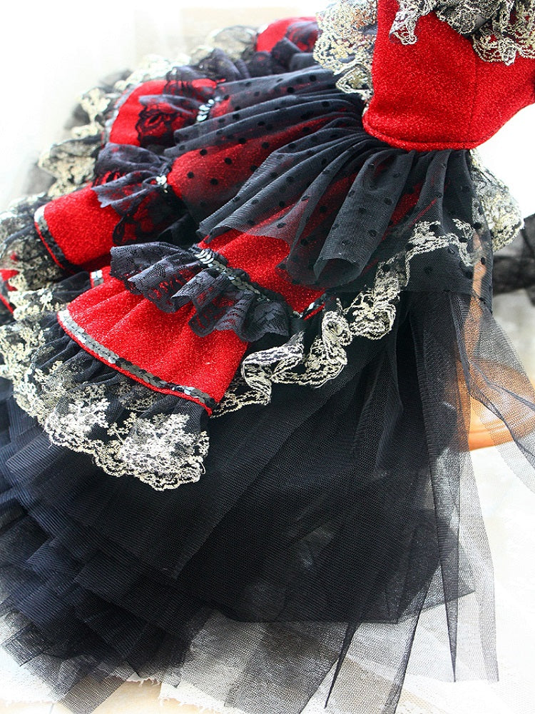 Close-up of a black, red, and white dress with lace details on a light background