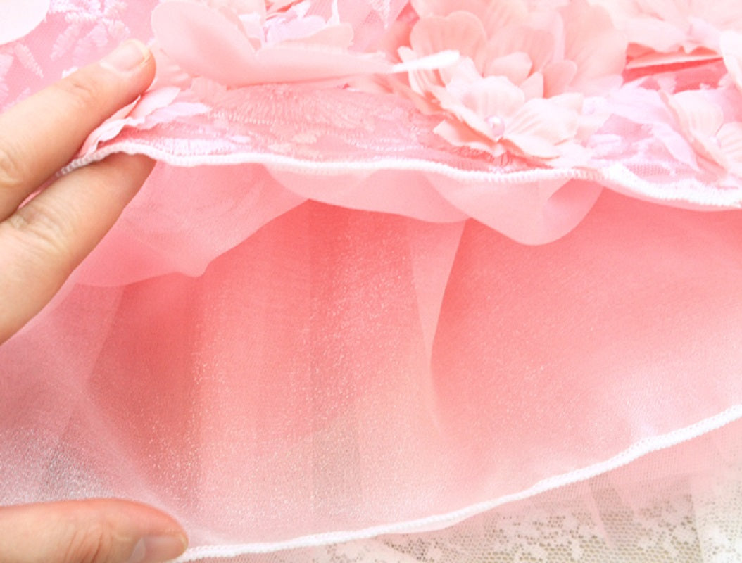 Close-up of a hand holding a pink fabric with floral patterns