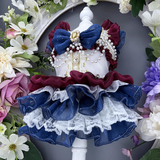 Decorative headpiece with blue and red bows and pearls, surrounded by flowers.