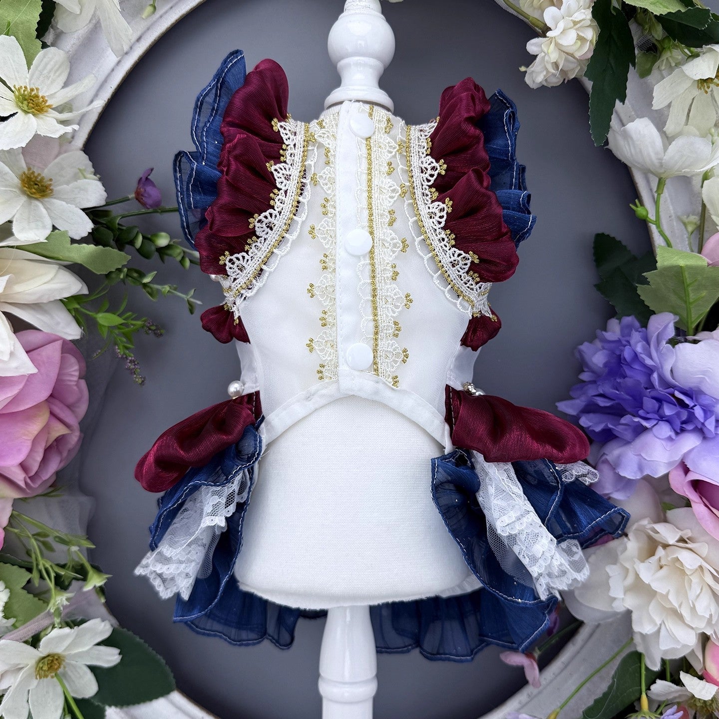 Decorative headpiece with ruffles and lace surrounded by flowers on a dark background