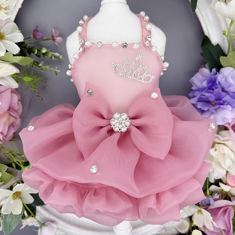 Pink pet dress with decorative elements on a mannequin against a floral background