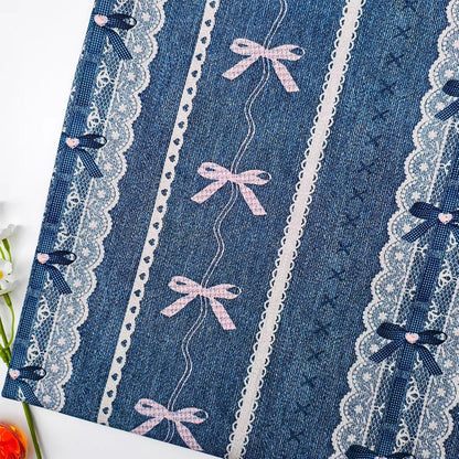 Blue fabric with lace and pink bows on a white background