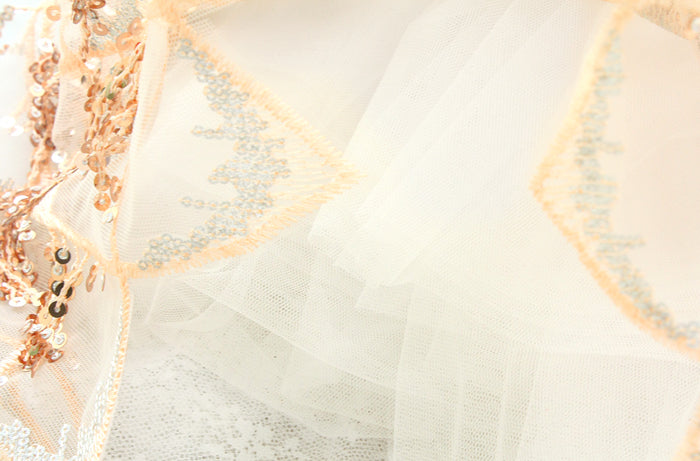 Close-up of a decorative item with geometric patterns and rose gold accents on a light background