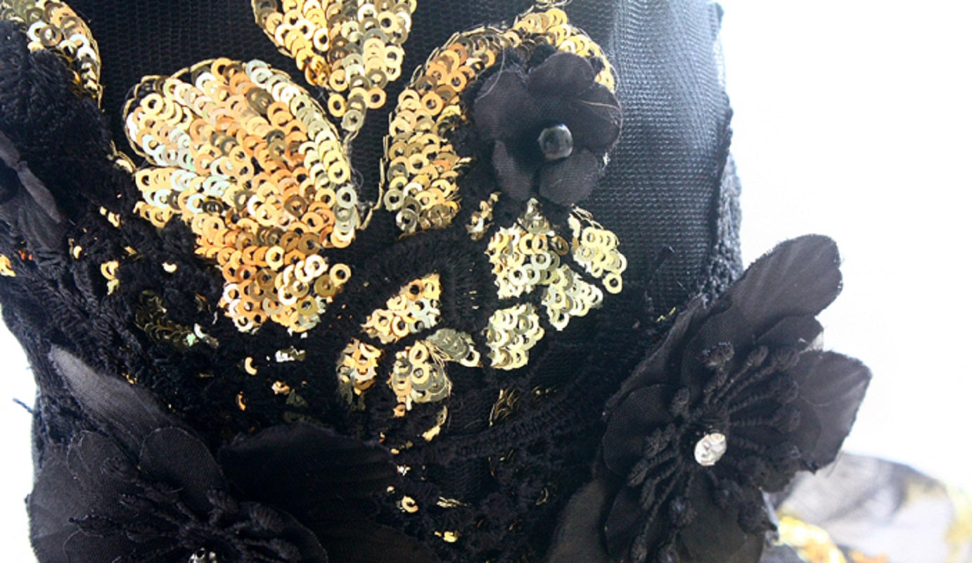 Black lace headband with gold sequins and black flowers on a white background