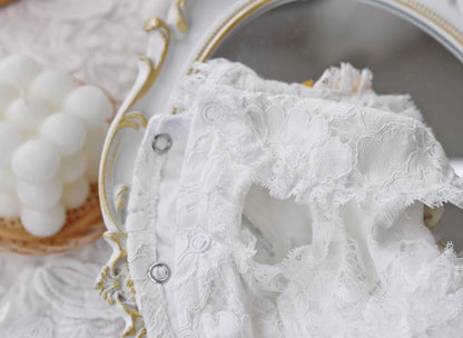 Close-up of a lace garment with a decorative plate in the background