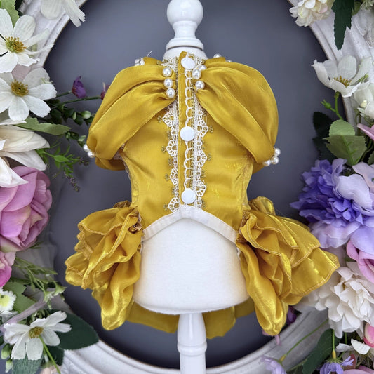 Yellow dress on a mannequin with floral decorations in the background