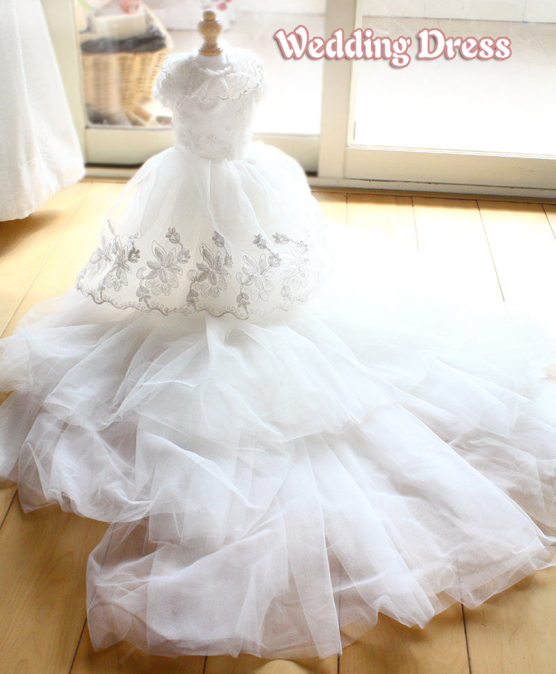 White wedding dress with floral details on a wooden floor