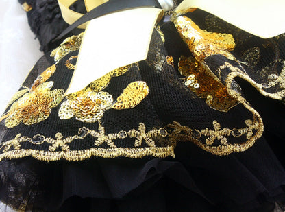 Black dress with gold embroidery and sequins on a white background