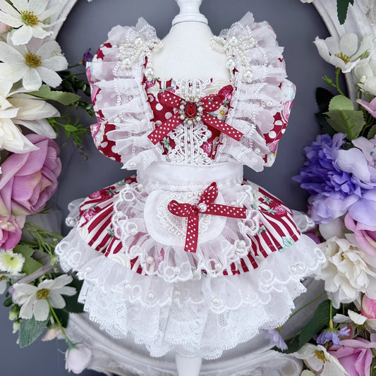 Delicate white and red lace dress on a mannequin with floral decorations.