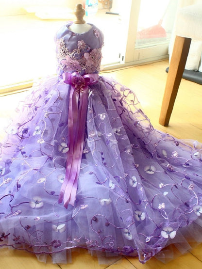 Purple ball gown with floral details on a mannequin against a neutral background