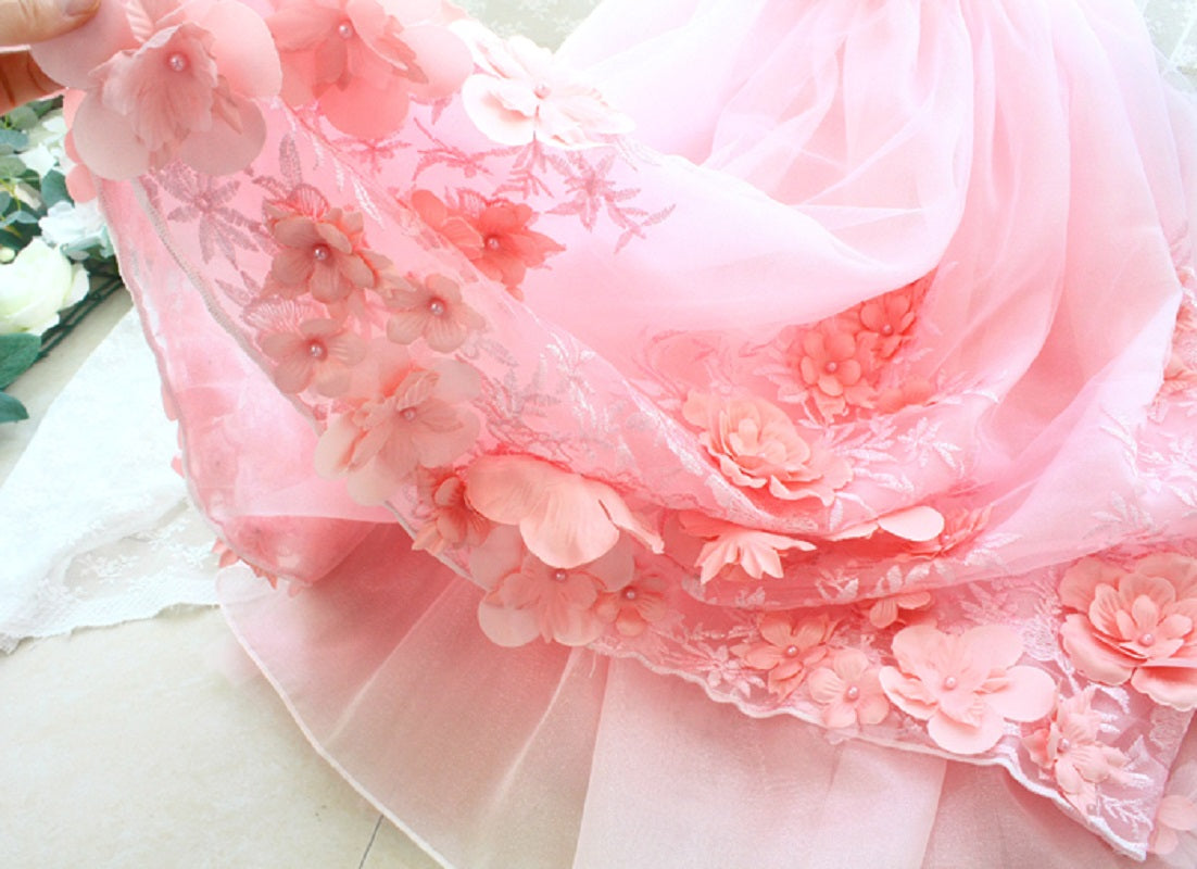 Close-up of a pink floral dress with intricate details on a light background
