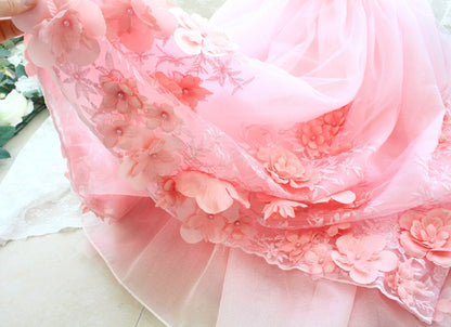 Close-up of a pink floral dress with intricate details on a light background